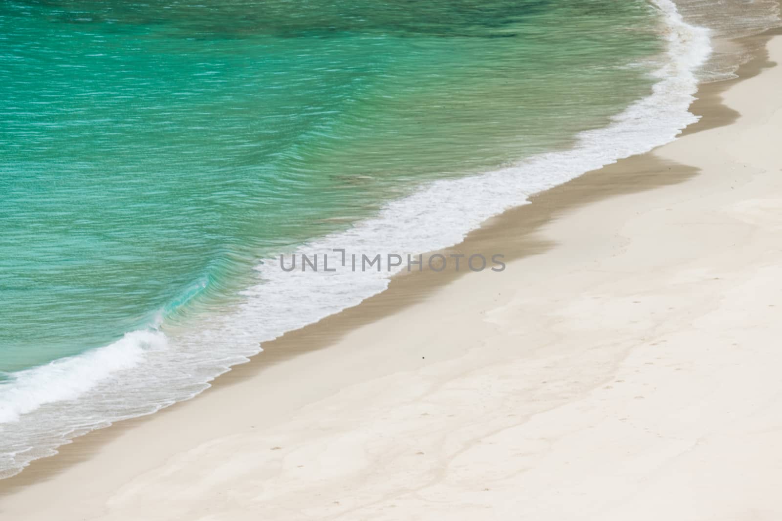 white sandy beach and turquoise sea water on sunny day by Khankeawsanan