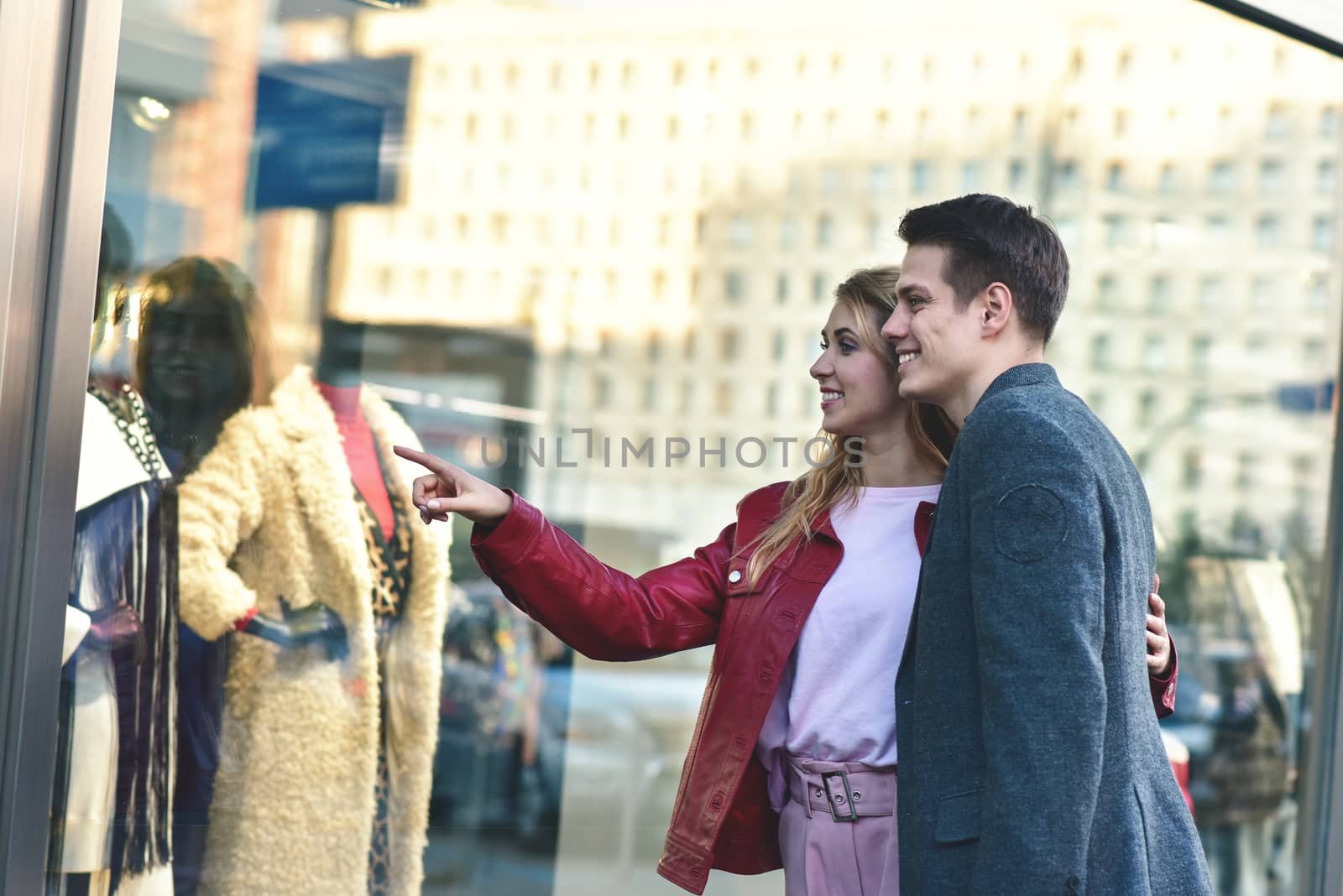 Beautiful young couple enjoying in shopping, having fun together. Consumerism, love, dating, lifestyle concept