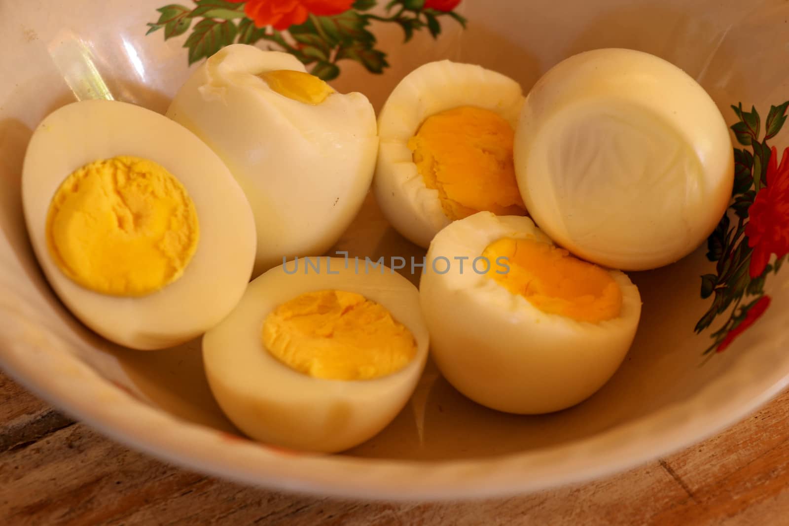 close up of half boiled eggs on wooden bowl by Sanatana2008