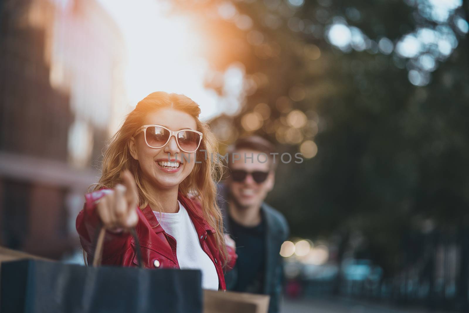 Couple in shopping together. Young couple holding hands and running through street.