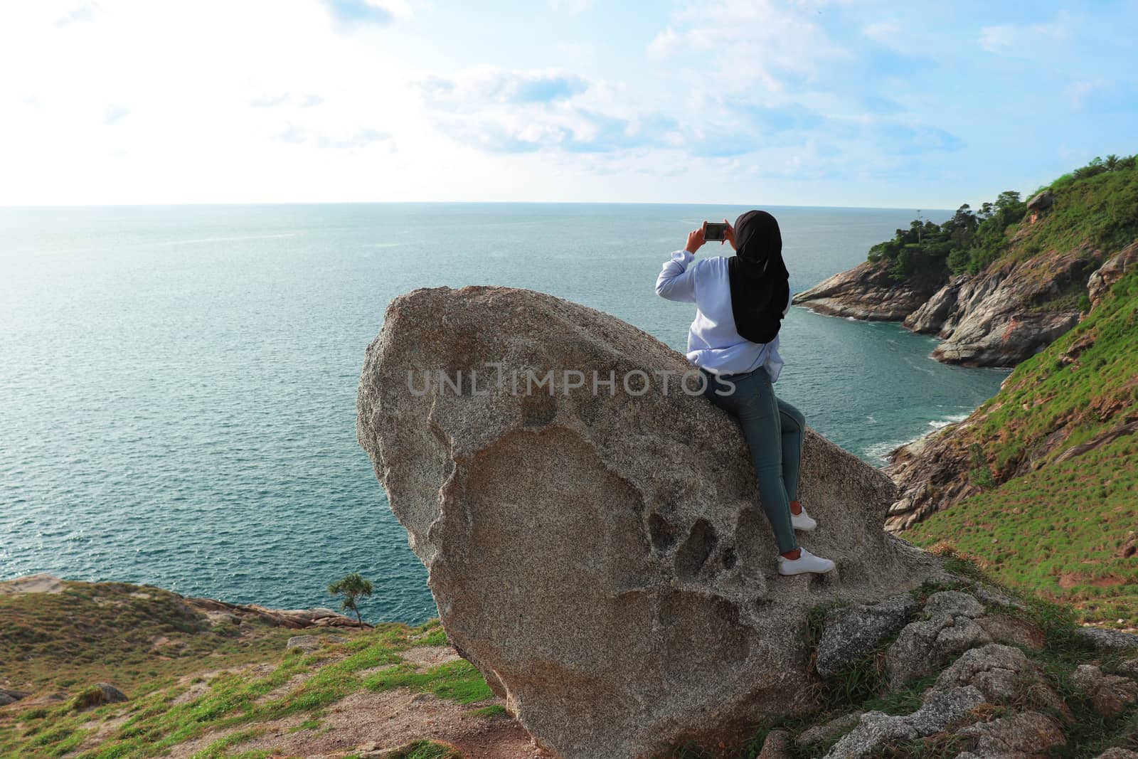Woman sitting and take photo of the Andaman sea at Krating cape  by Khankeawsanan