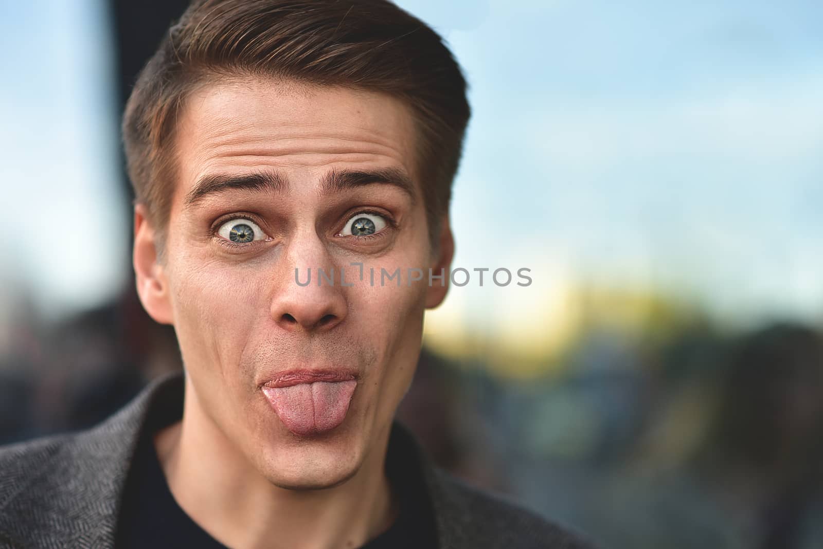 Portrait of stylish happy handsome young man standing outdoors. by Nickstock