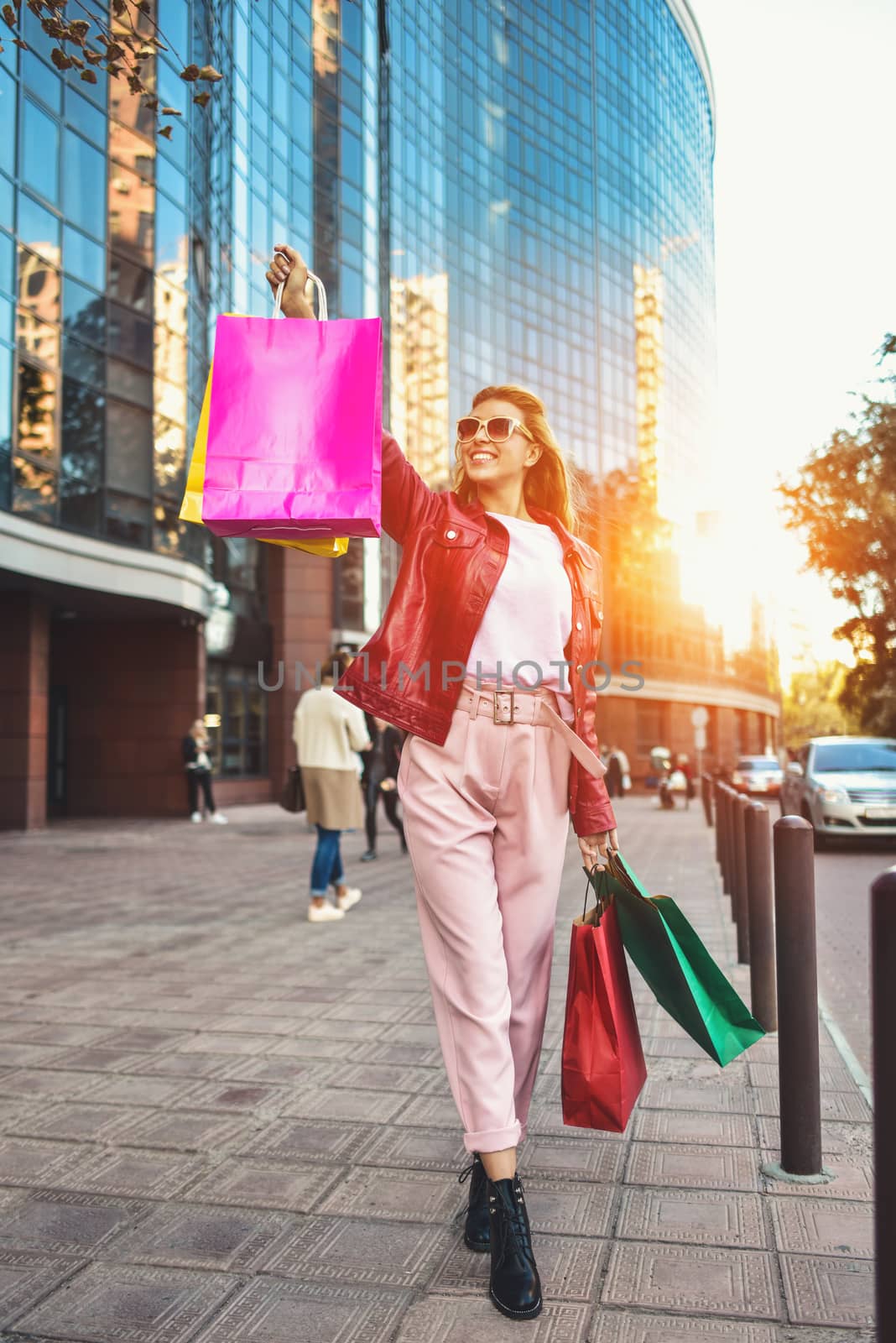 Shopping woman walking outside at street holding shopping bags. Shopper smiling happy walking the street after shopping