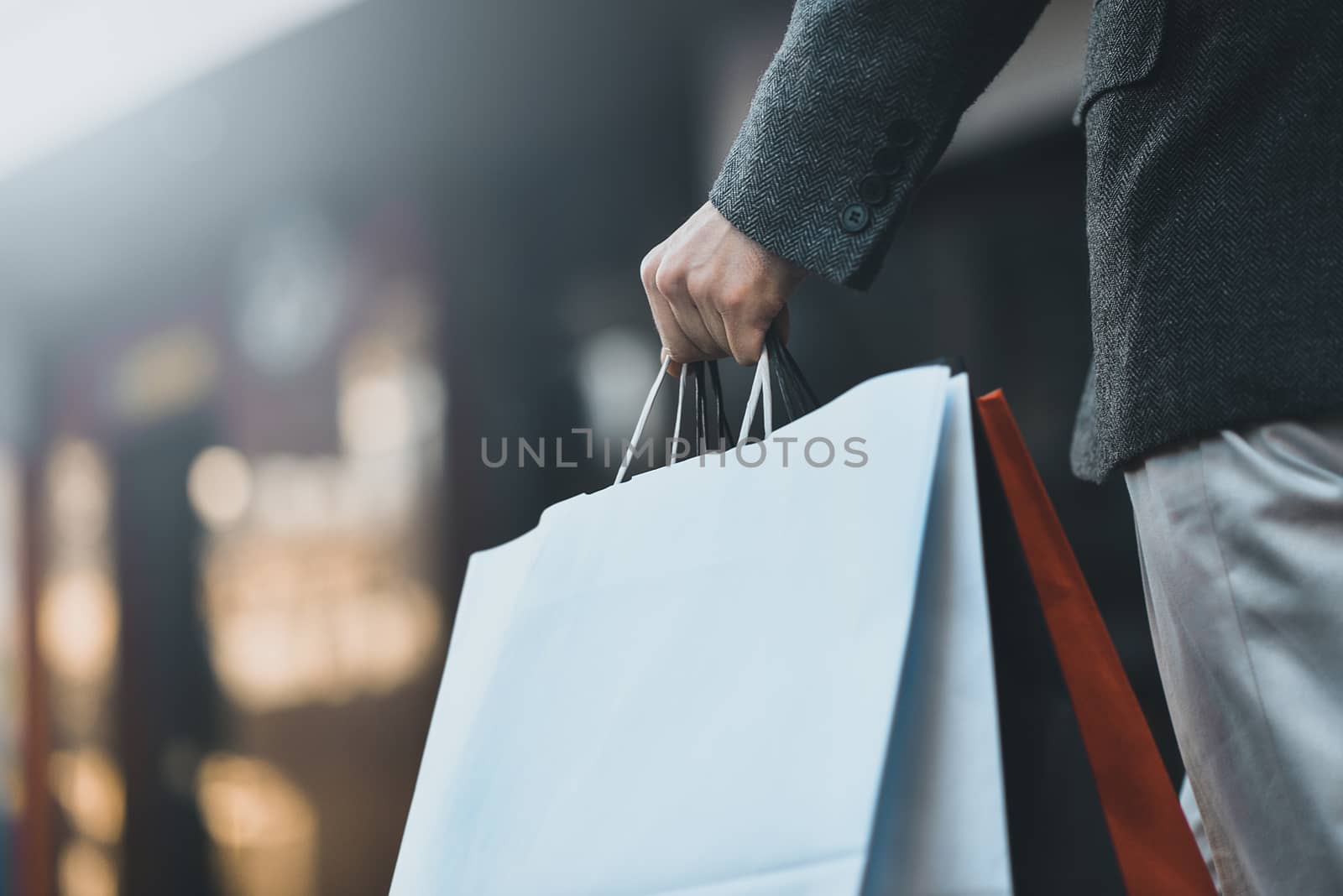 Concept of man shopping and holding bags, closeup images. Close up of paper shopping bags in male hand. by Nickstock