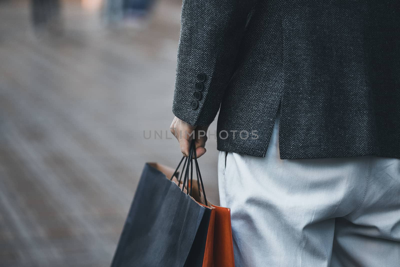 Concept of man shopping and holding bags, closeup images. Close up of paper shopping bags in male hand. by Nickstock