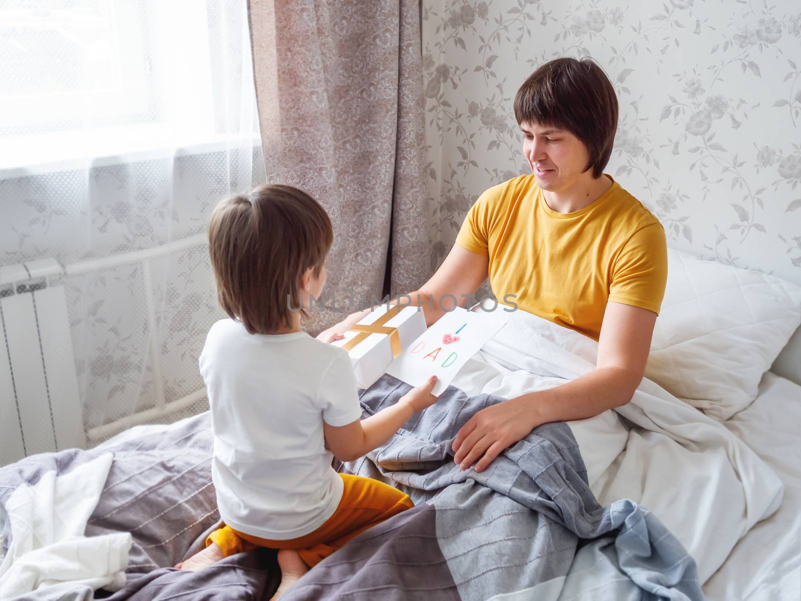 Happy Father's Day. Toddler gives present and handmade greeting by aksenovko