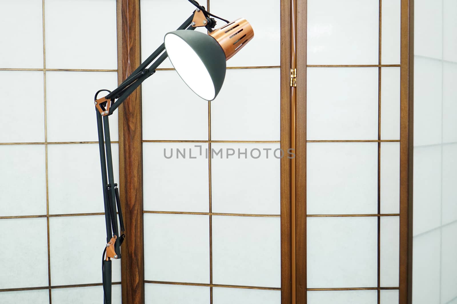 Screen with wooden inlays in a beauty salon. Metal lamp