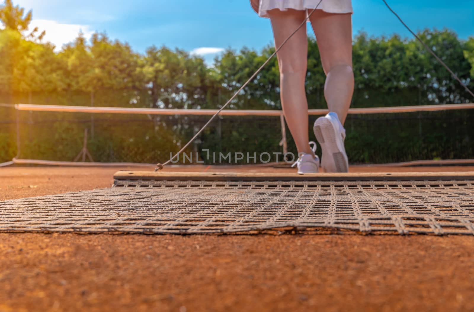 sweeping orange clay on an outdoor tennis court. copy space by Edophoto