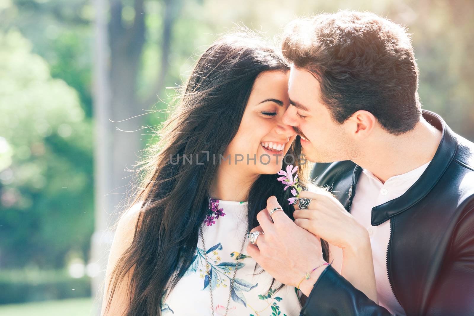 Young couple loving outdoors in a park. A young man and young woman kissing with passion and feeling. Love and falling in love.