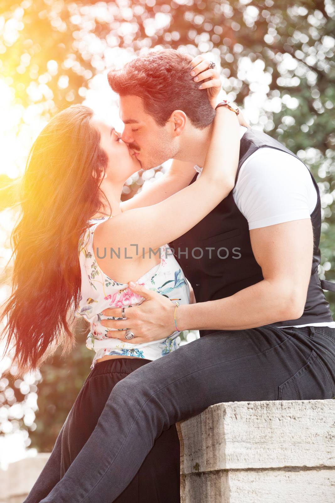 Passion and love. Couple. Harmony, tenderness, peace and love between two lovers. Young man and young woman embracing outdoors in nature. Intense feeling and fiery passion. Bright light behind.