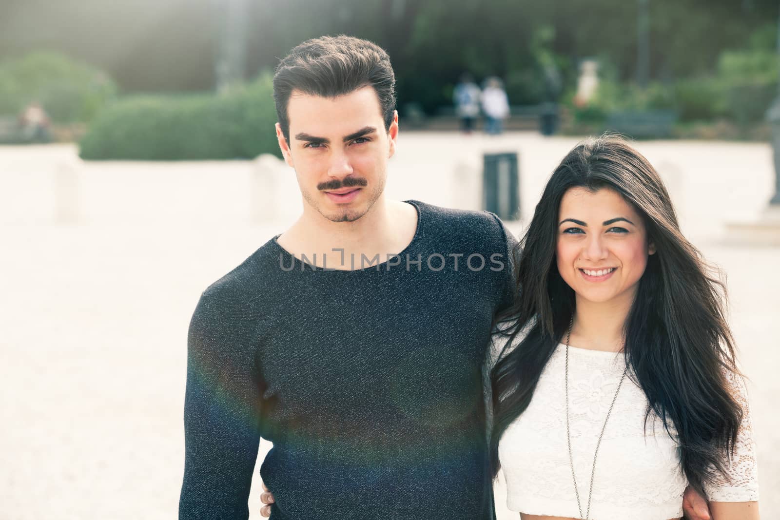 Beautiful embracing lovely young italian couple outdoors. A couple, young man and a smiling woman outdoors.