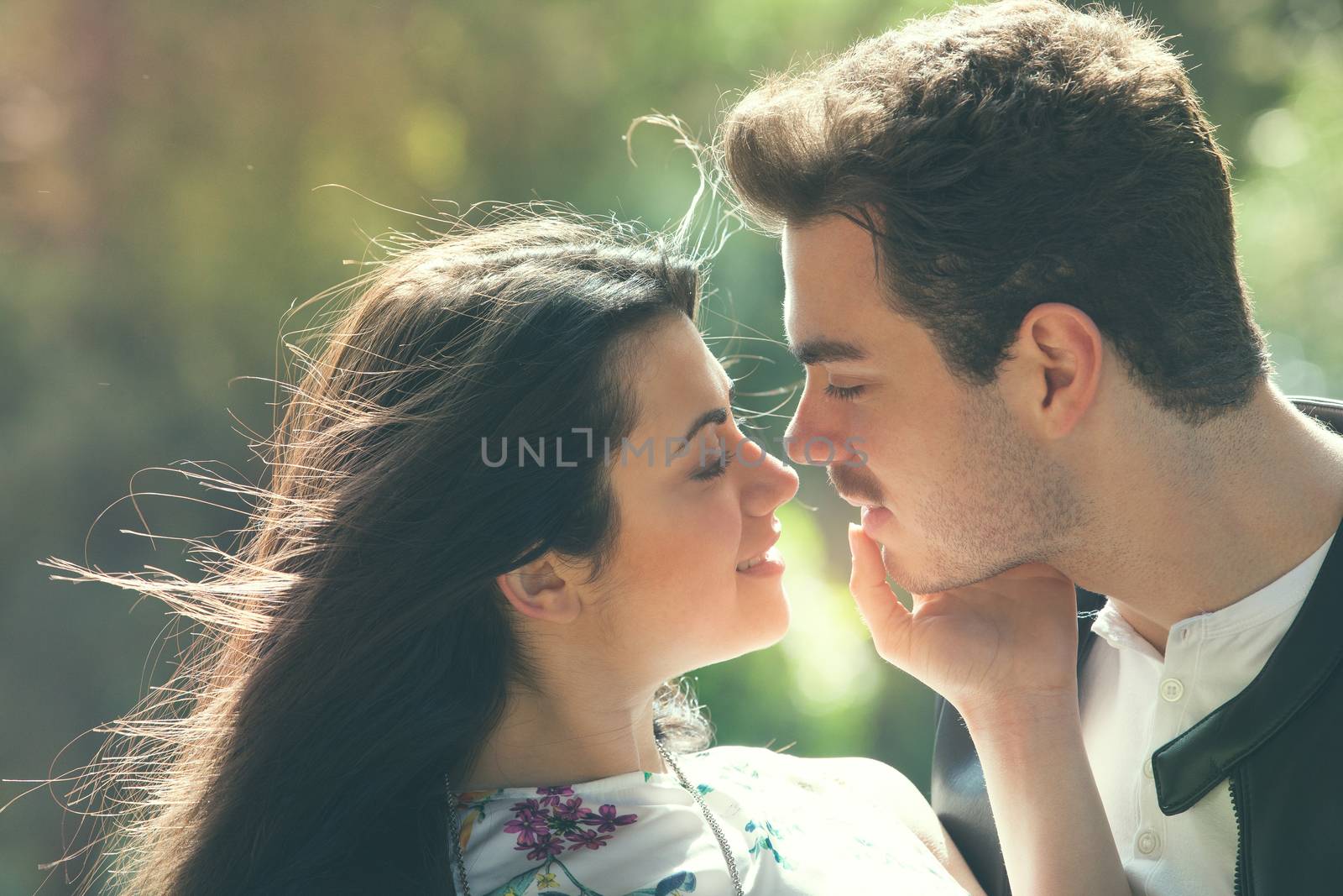 Young couple loving outdoors in a park. A young man and young woman embracing e kissing with passion and feeling. Love and falling in love. Black and white