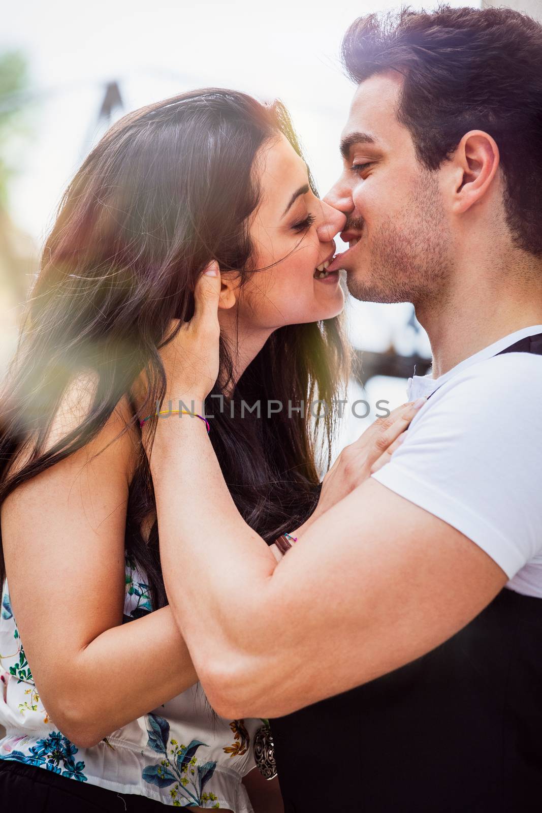 Loving couple girl kisses and bites the lip of her boyfriend. Intense love between two young people embracing each other.