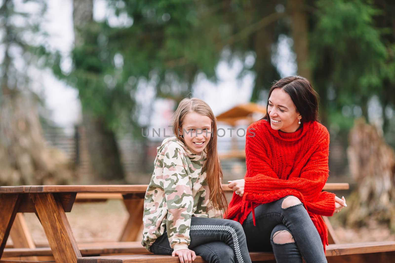 Mother and daughter playing with dog outdoors by travnikovstudio