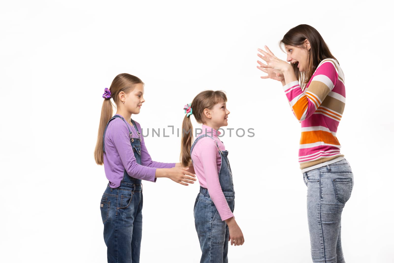 Mom scares her two daughters, isolated on white background