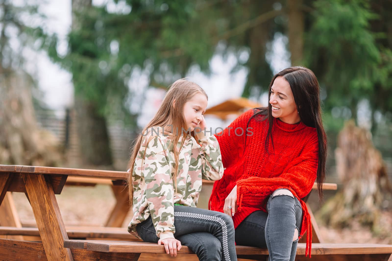 Mother and daughter playing with dog outdoors by travnikovstudio