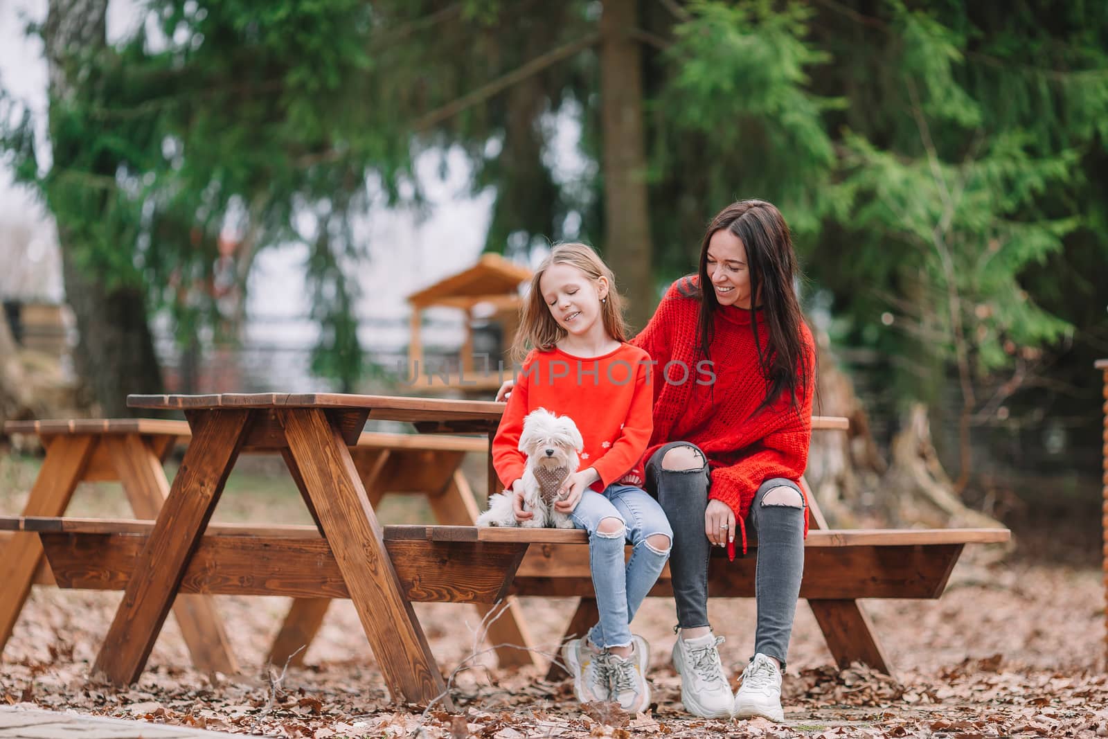 Adorable little girl and young mother with puppy outdoor by travnikovstudio