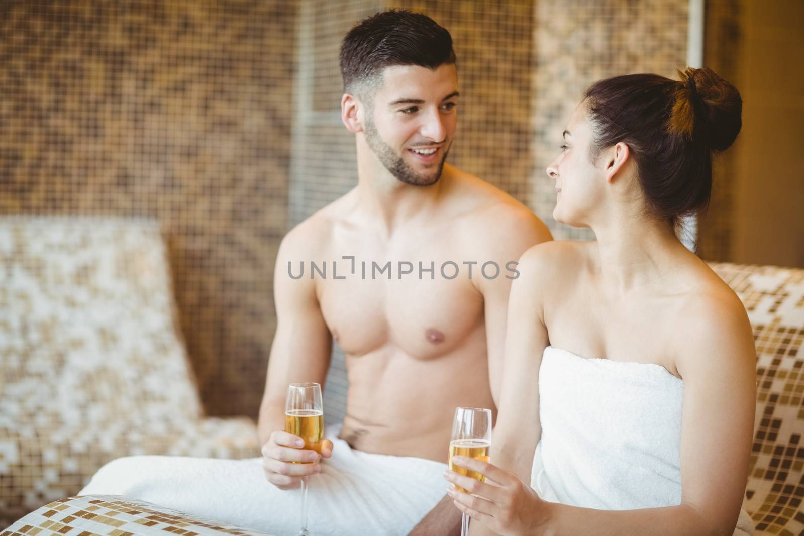 Romantic couple together with champagne glasses at the spa