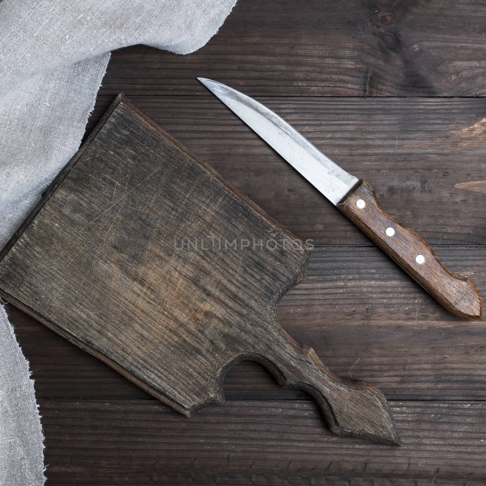empty old brown wooden cutting board and knife  by ndanko