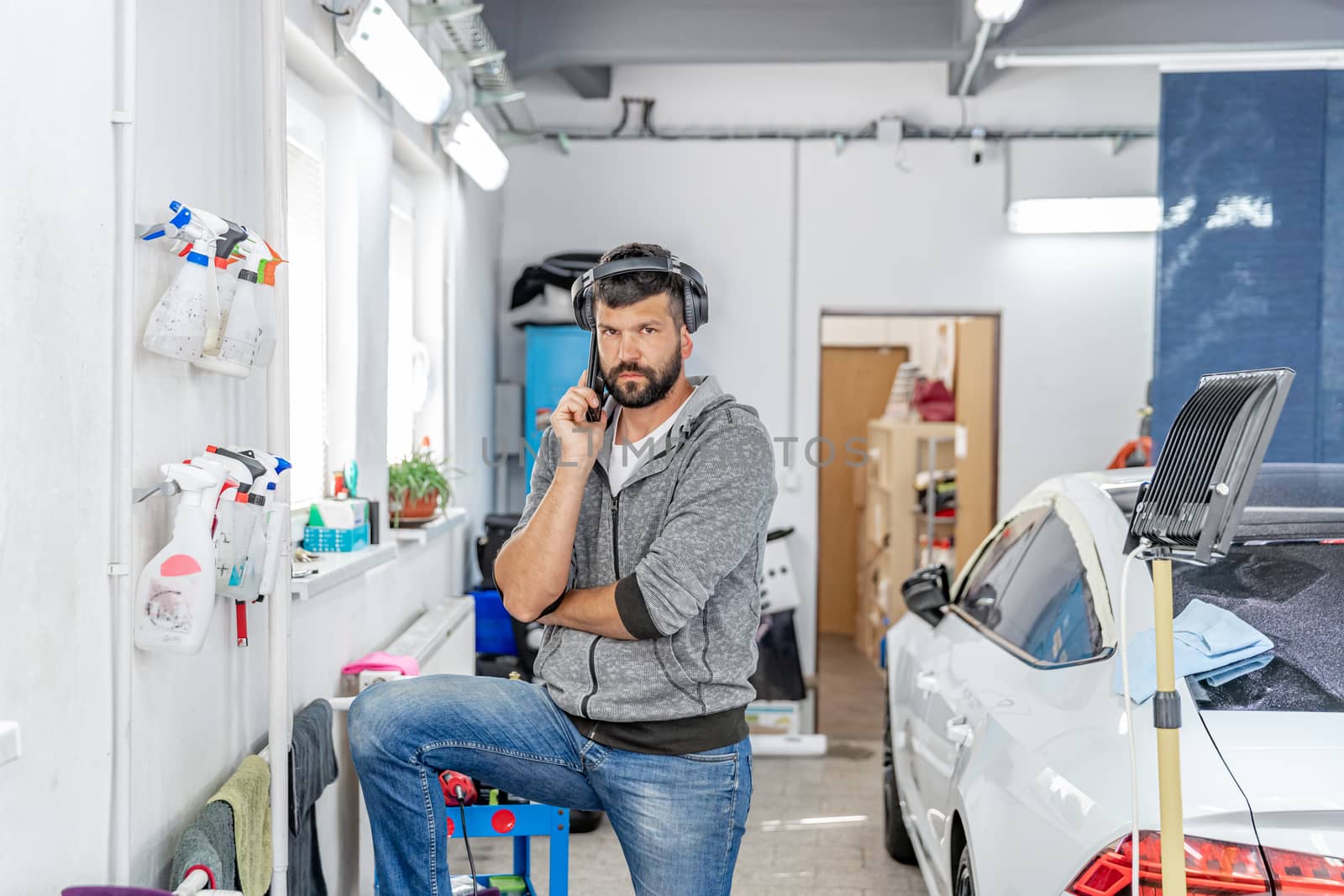 phoning mechanic in the garage for manual washing and cleaning of cars by Edophoto