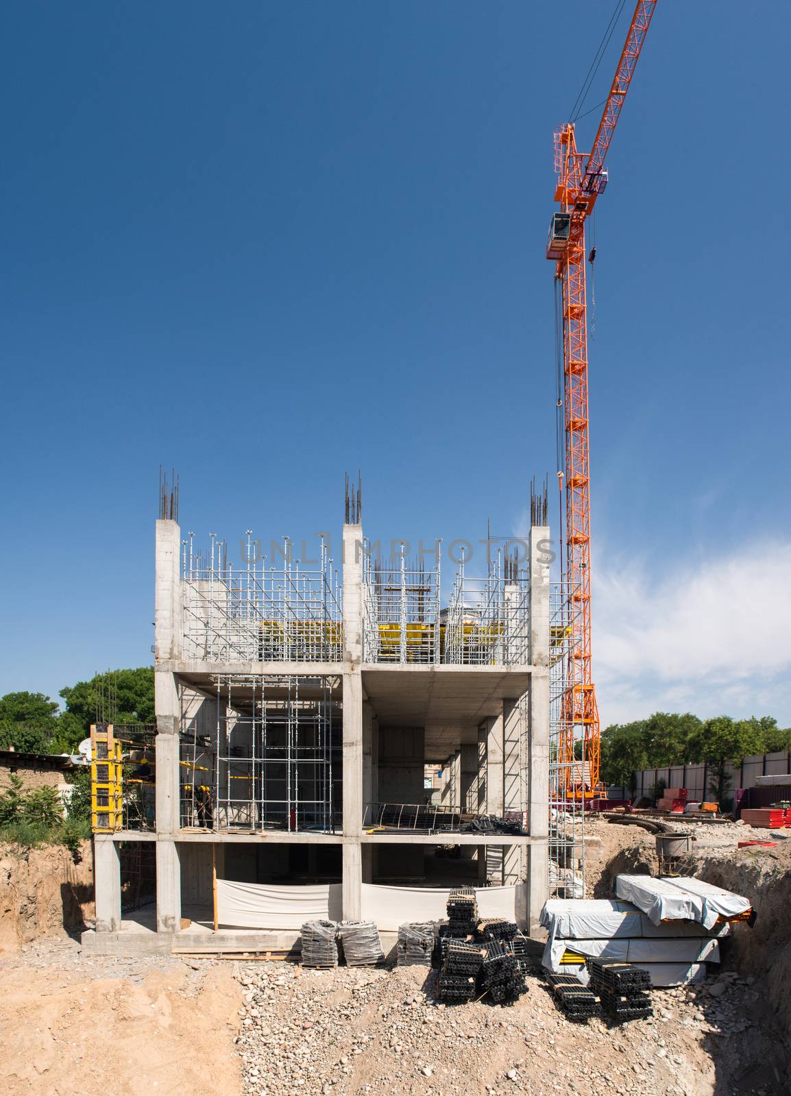 construction crane and a concrete structure of the building on a background the sky