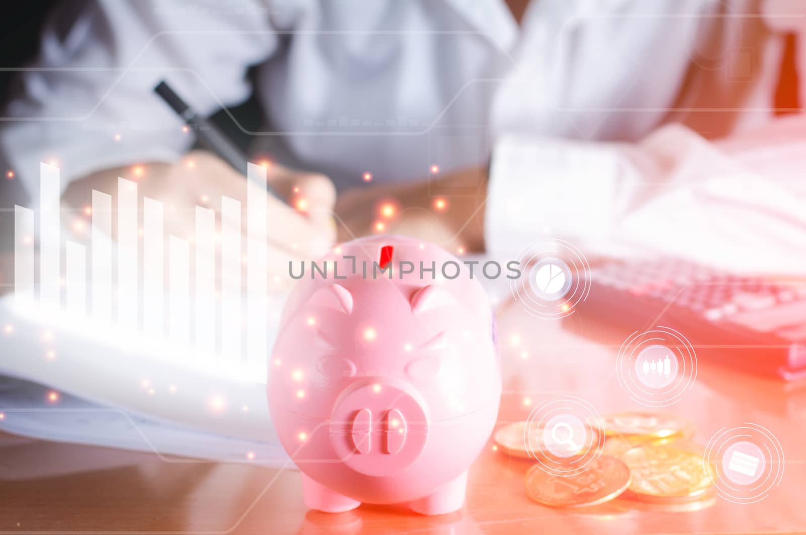 Business and analysis concept. Pink piggy bank on wooden table with white graph and chart icon analysis financial on virtual screen, positive growth of money and stock.