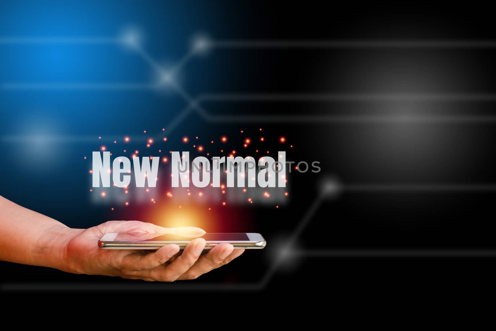 White world new normal on hand holding smartphone with orange light on blue and black technology background. New normal concept.