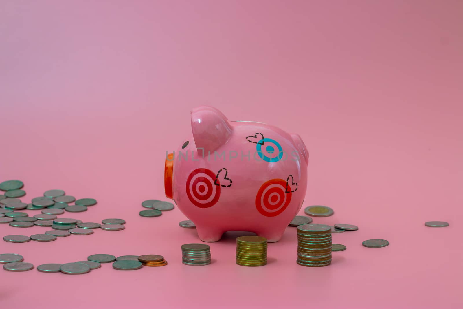 Pink piggy bank and coins on pastel pink background, Financial concepts
