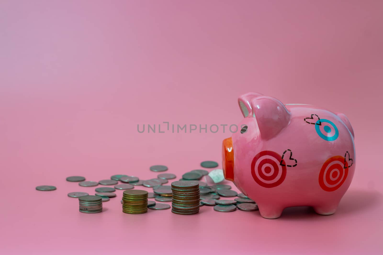Pink piggy bank and coins on pastel pink background, Financial concepts