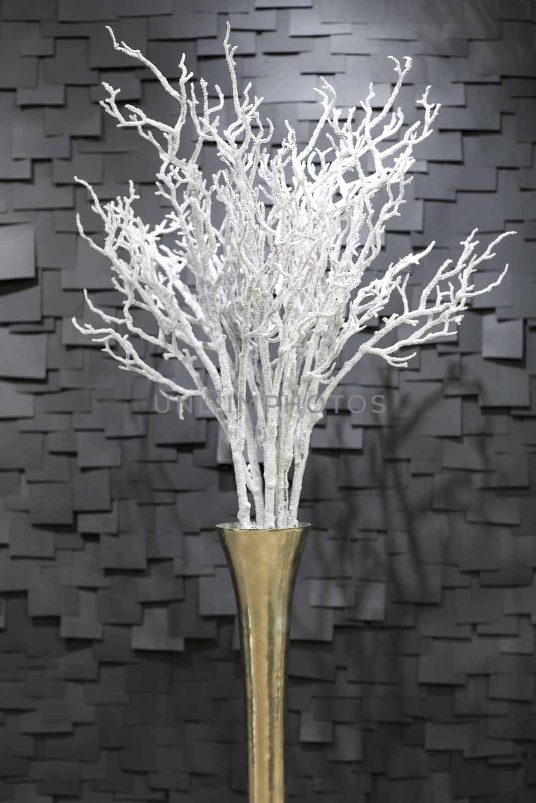 handmade artificial white a snowy branch in a pot on a dark background in the form of tiles