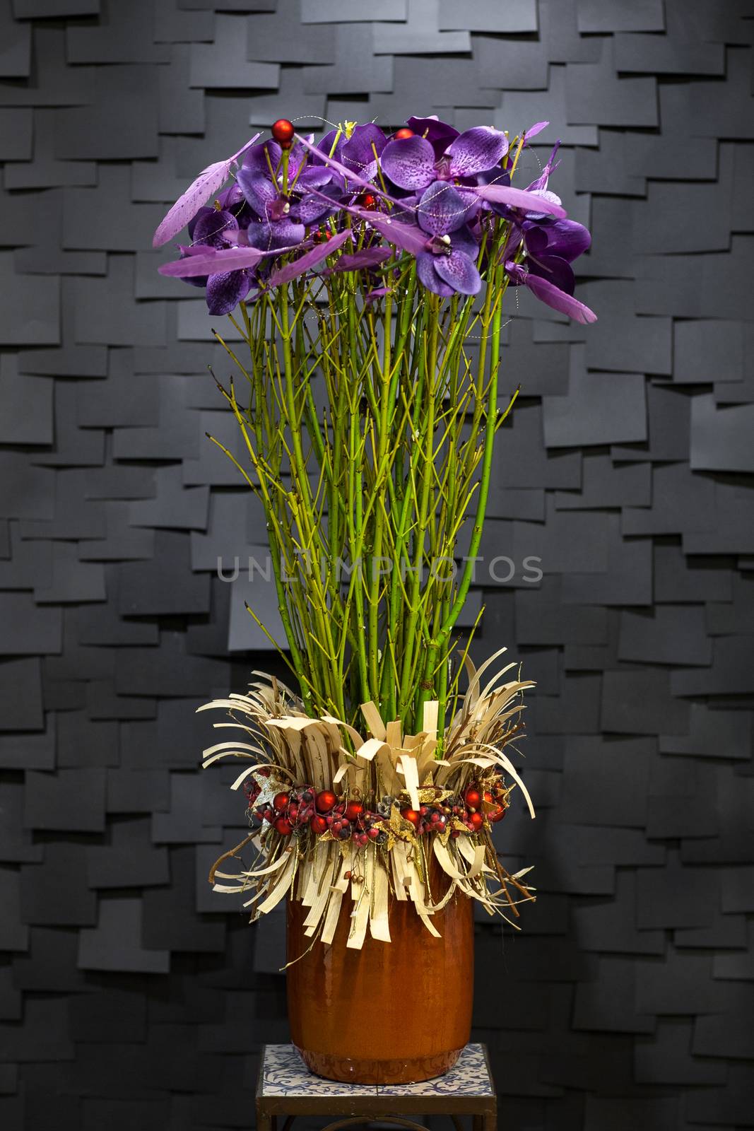 purple flower with a long stem decorations in a pot on a dark background in the form of tiles