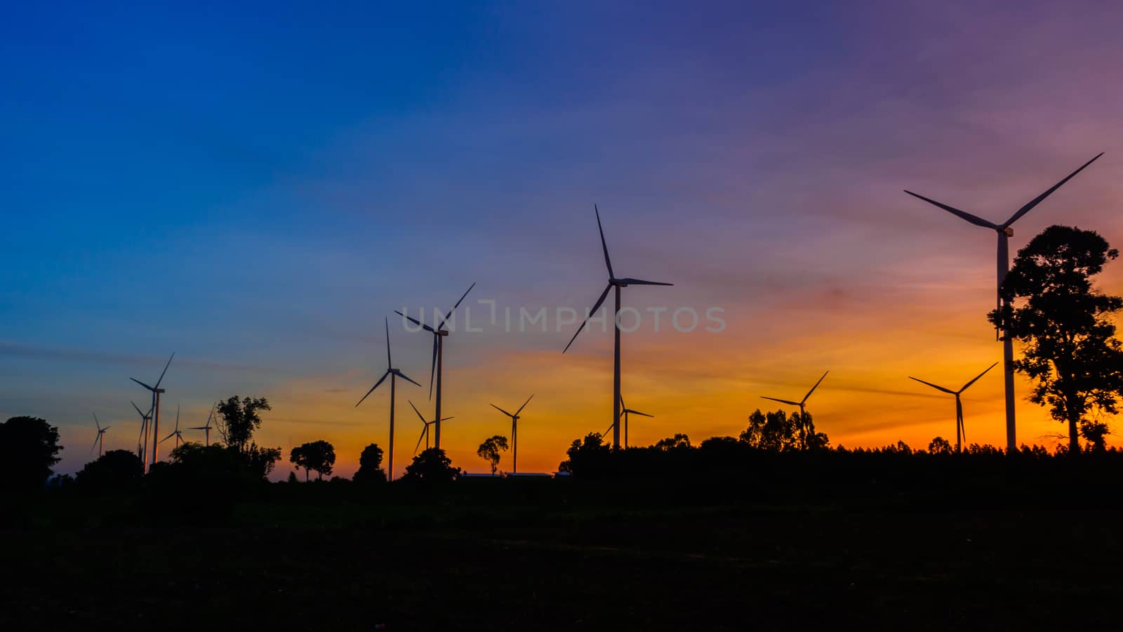 Wind turbines silhouette at sunset by joeasy
