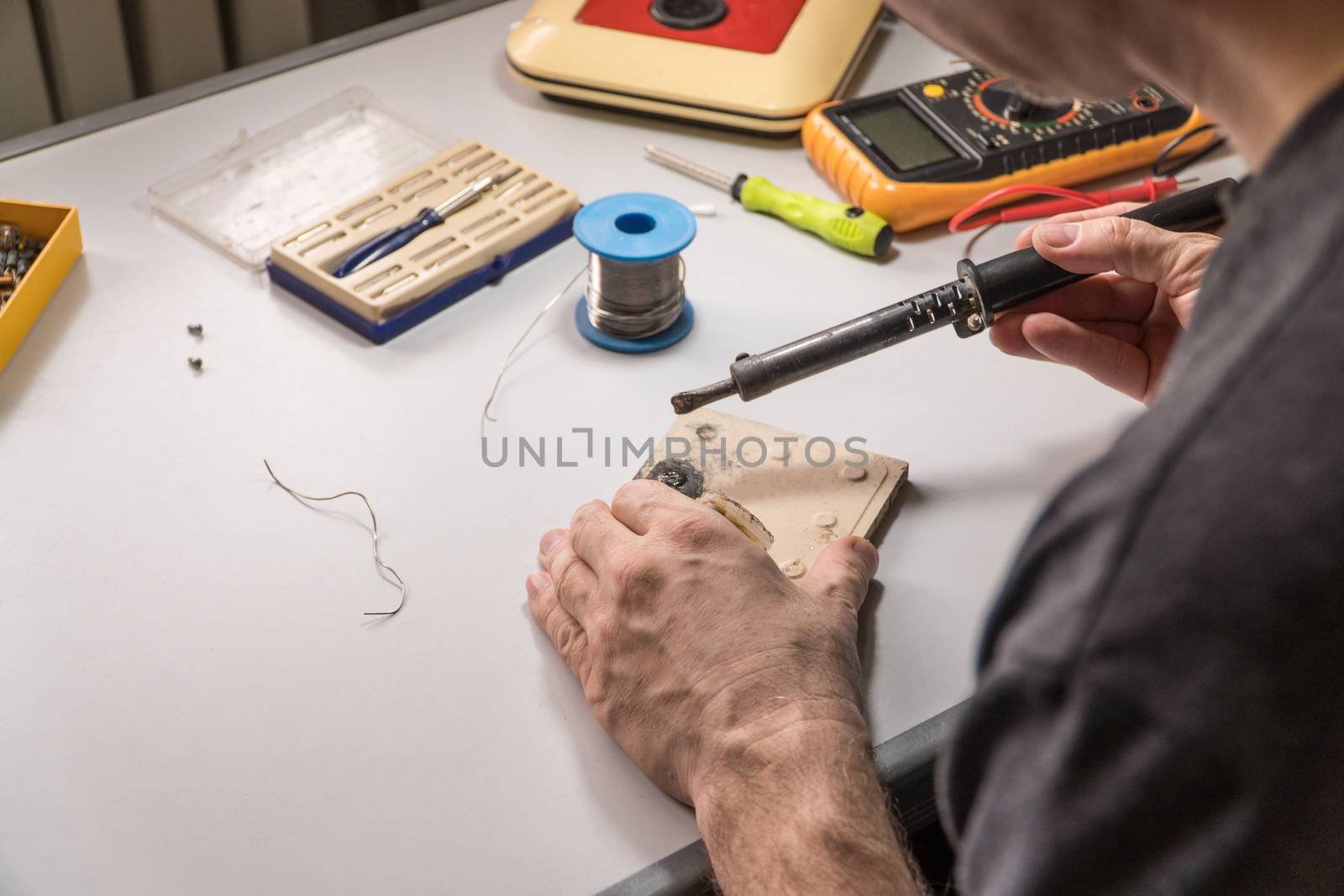 technician electrician prepares rosin soldering iron to work