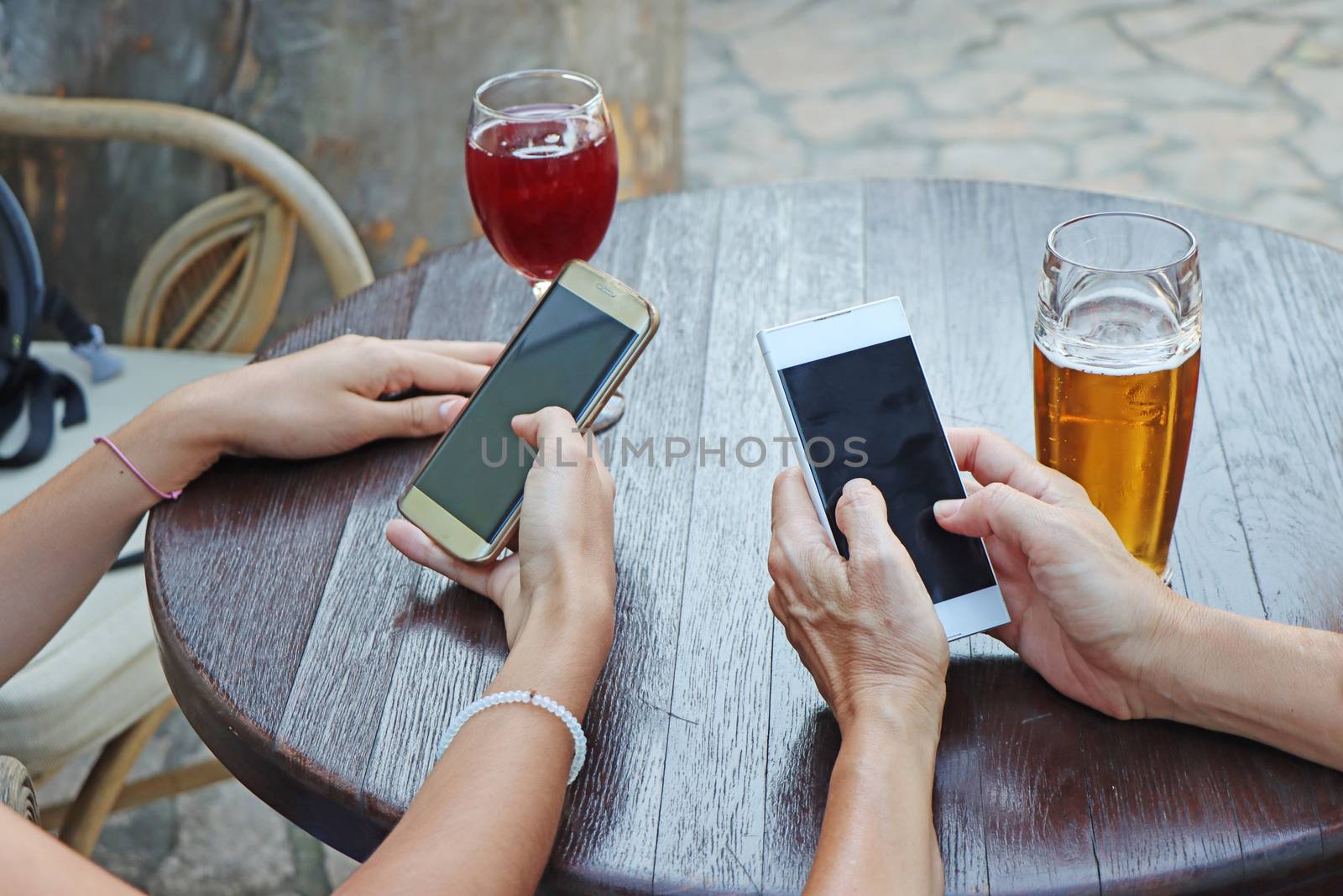 Two young girls watching smart mobile phones