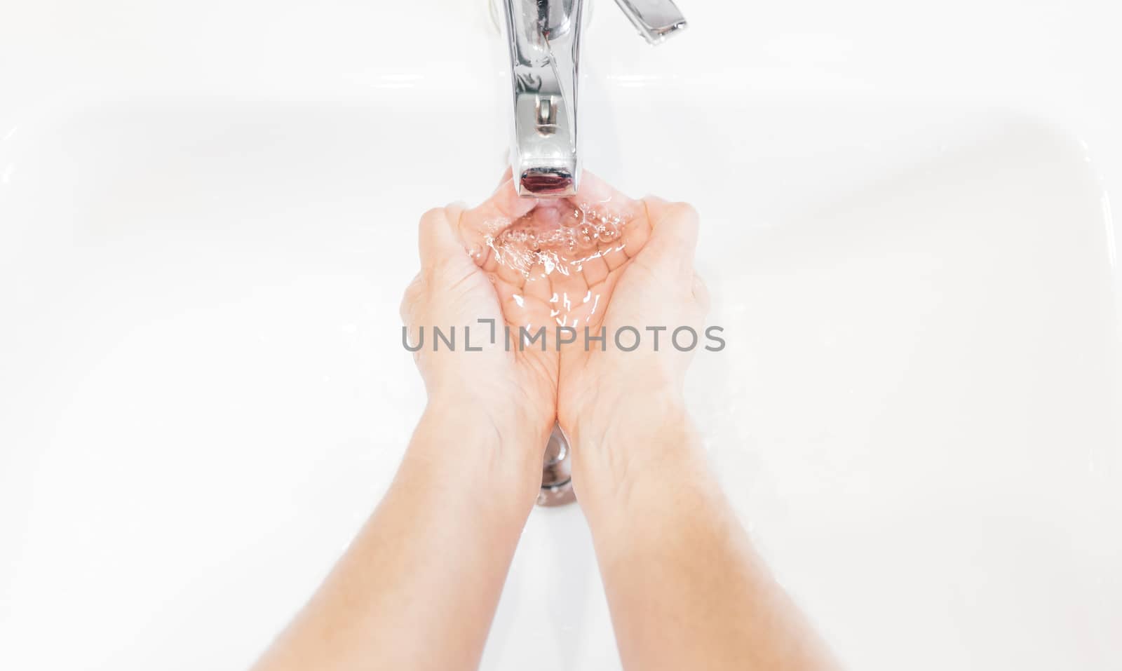 Man washing his hands hygienically with soap under the tap