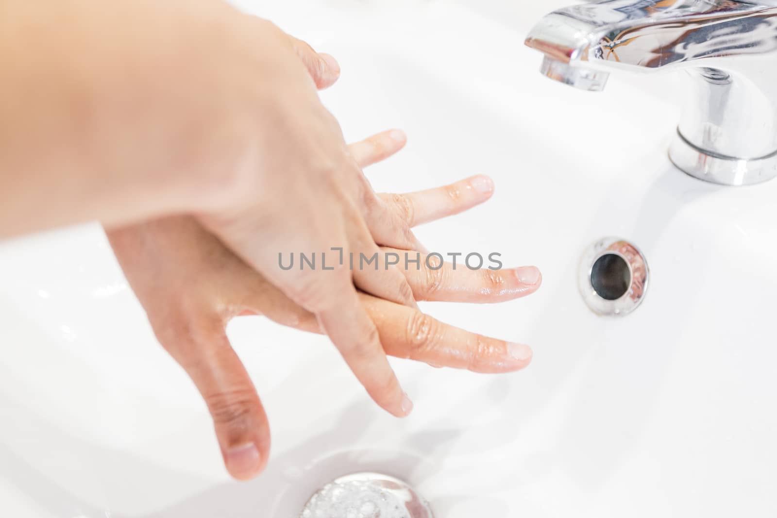Man washing his hands hygienically under the tap in times of coronavirus