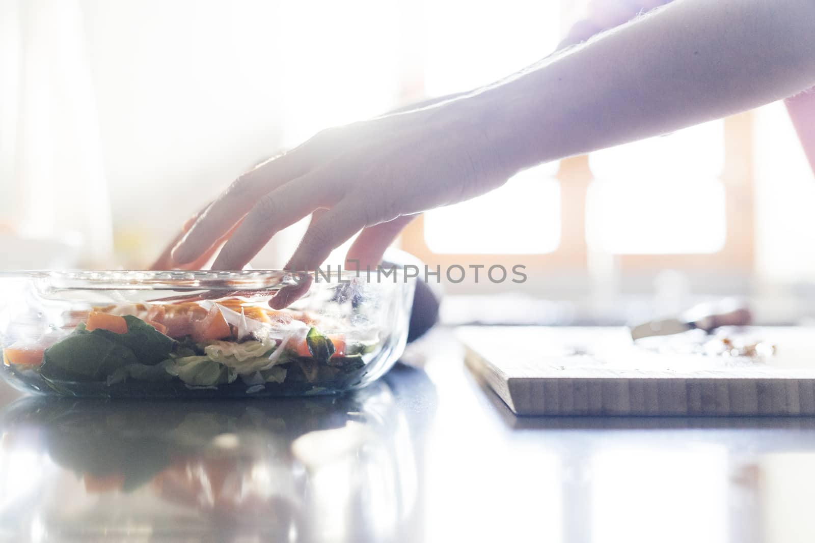 Woman preparing salad in the kitchen with her hands by Daniel_Mato