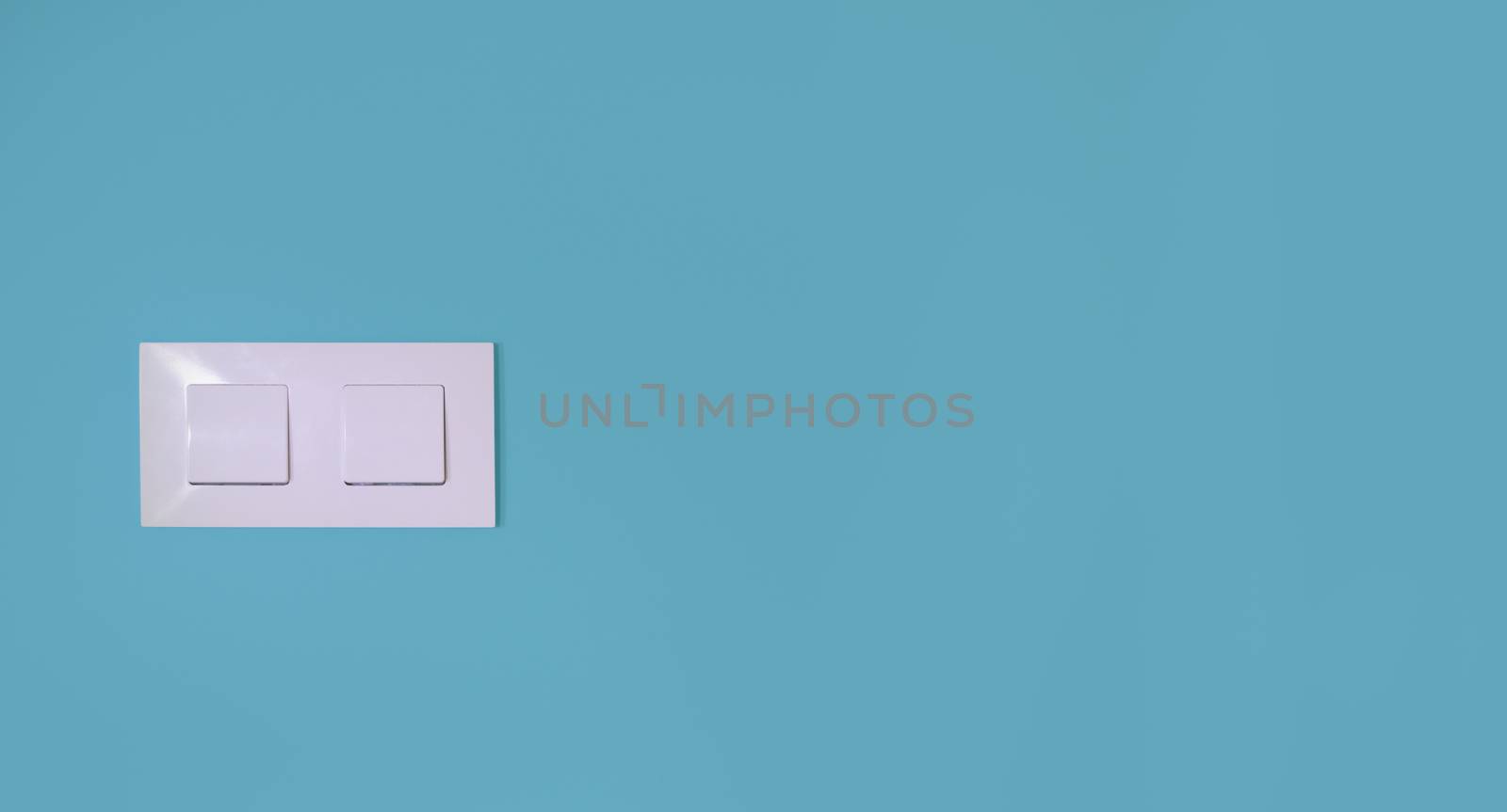 Light switch on a blue wall with copy space