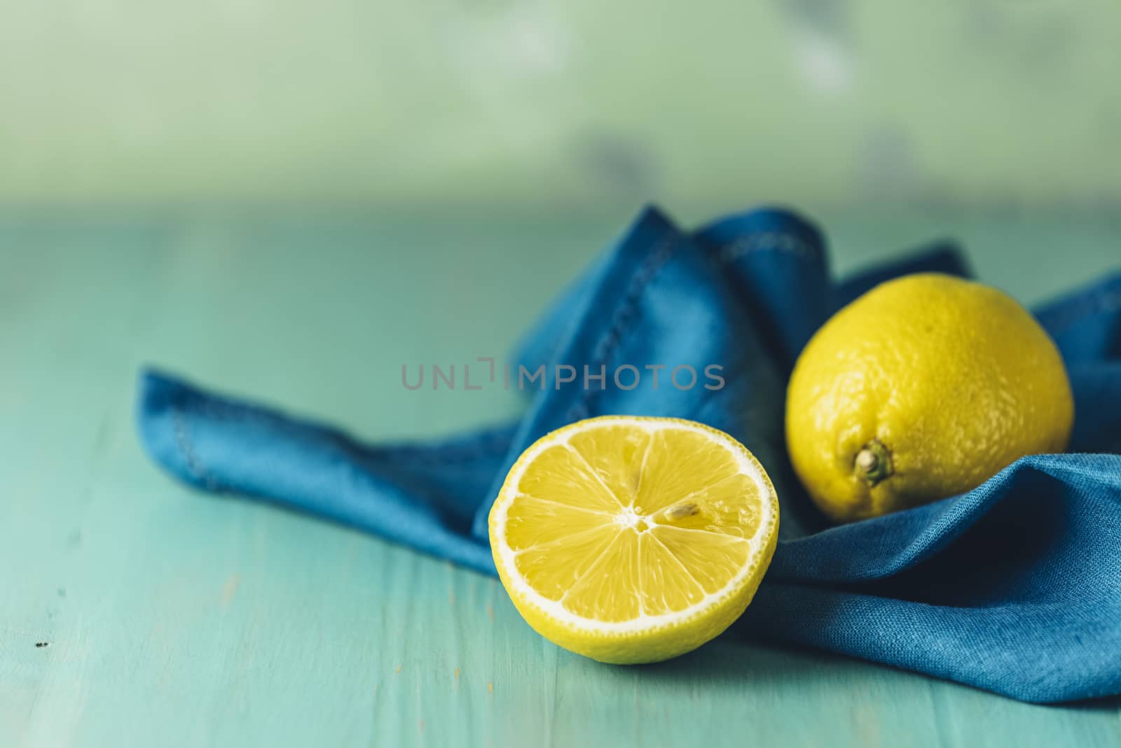 Ripe juicy lemon on wooden turquoise table surface. Close up, copy space for you text, shallow depth of the field.