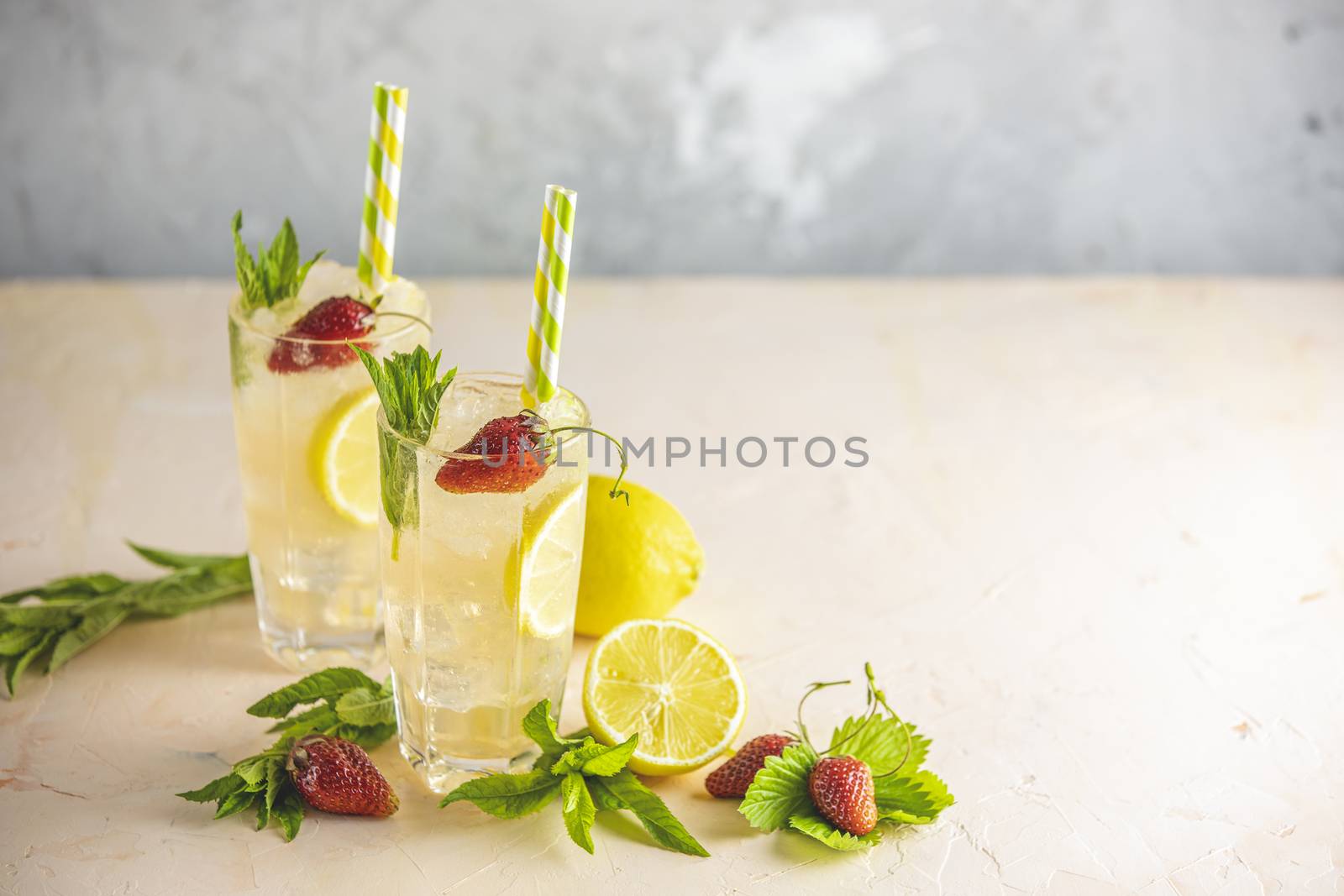 Two glasses of cold icy refreshing drink with lemon and strawber by ArtSvitlyna
