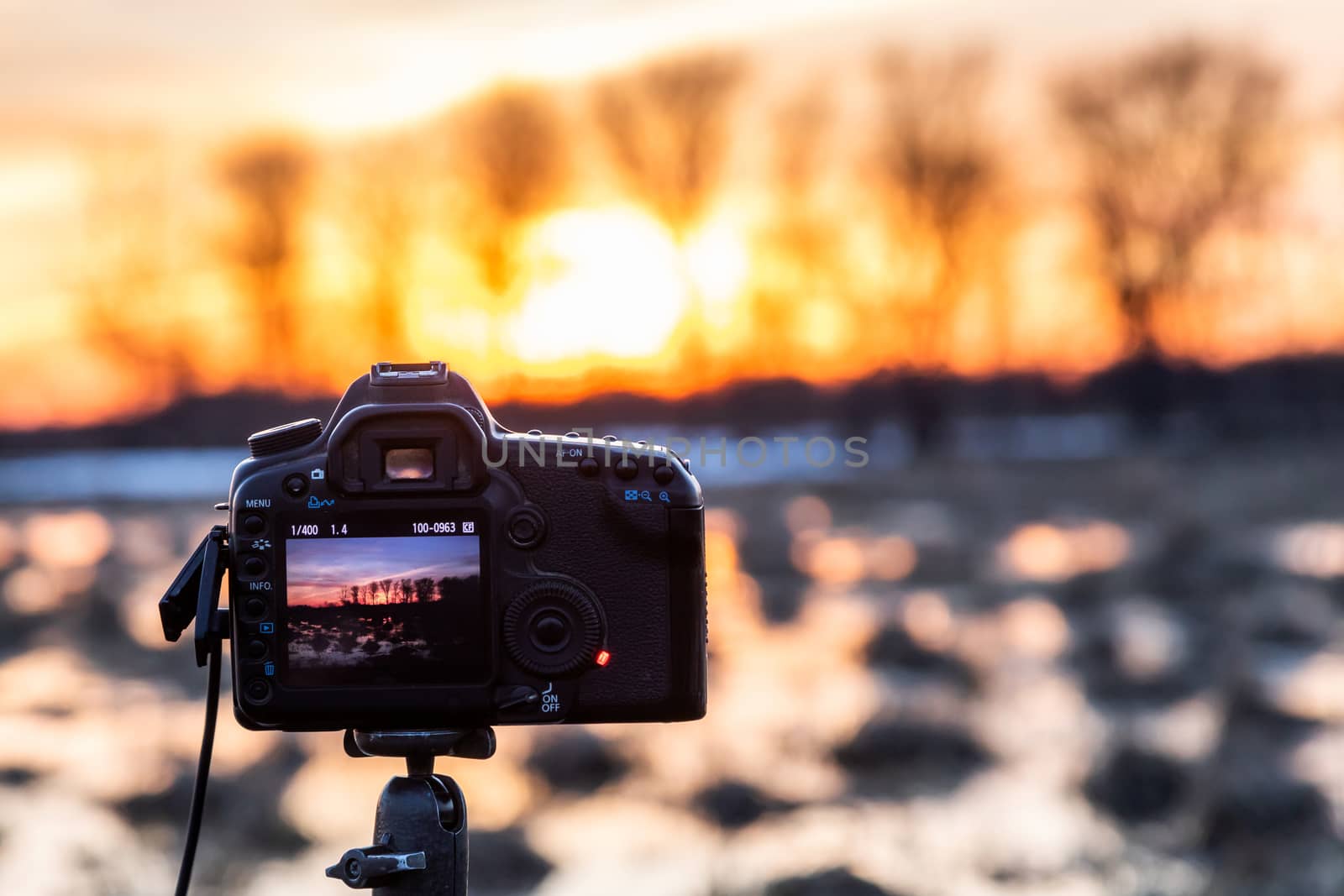 The camera takes a landscape photo on a tripod