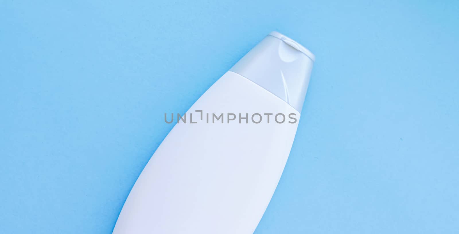 Blank label cosmetic container bottle as product mockup on blue background, hygiene and healthcare