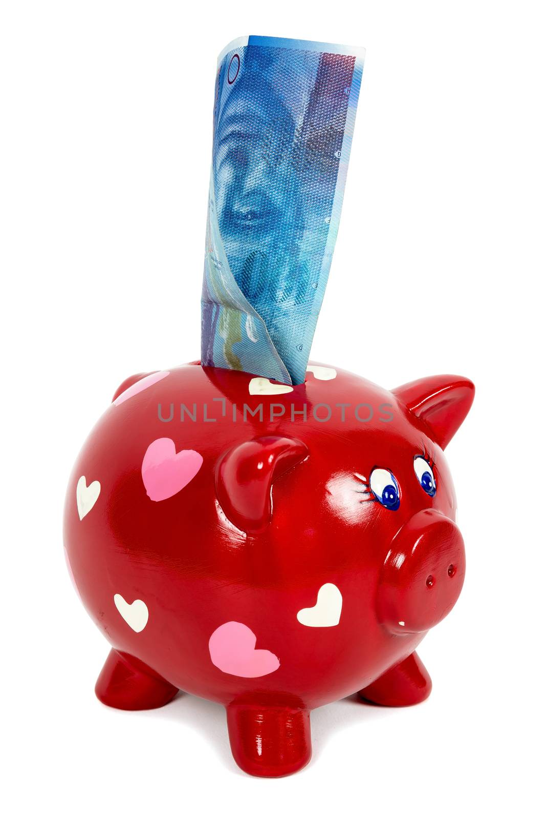 Red piggy bank with hearts and 100 swiss franc banknote isolated on white background with clipping path