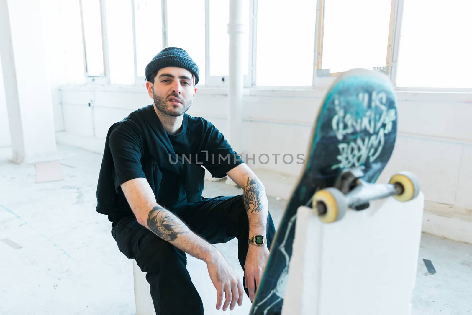 Portrait of relaxed young fashionable skater man in black outfit