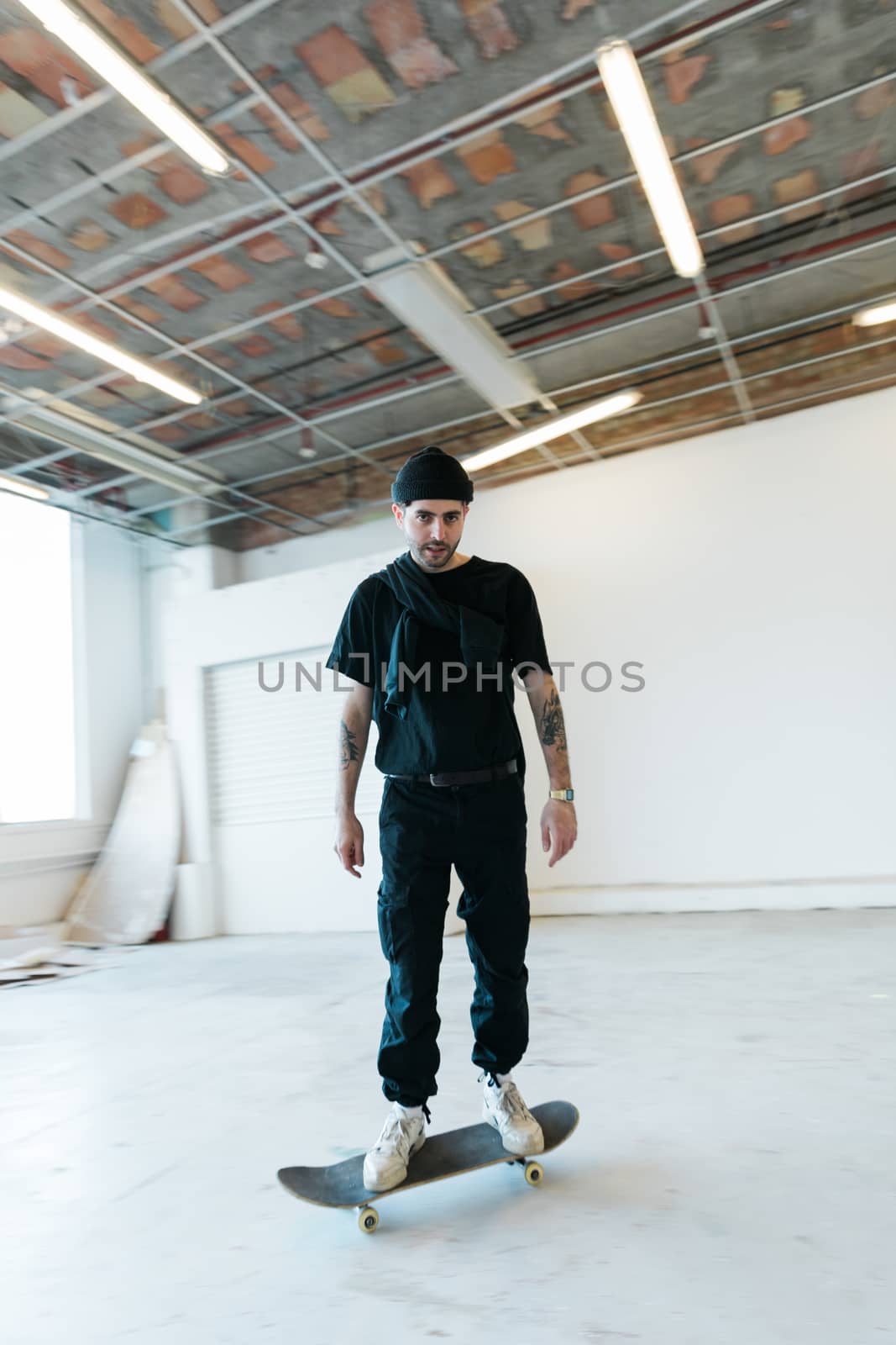 Young skater on his board in motion staring at the camera by camerarules