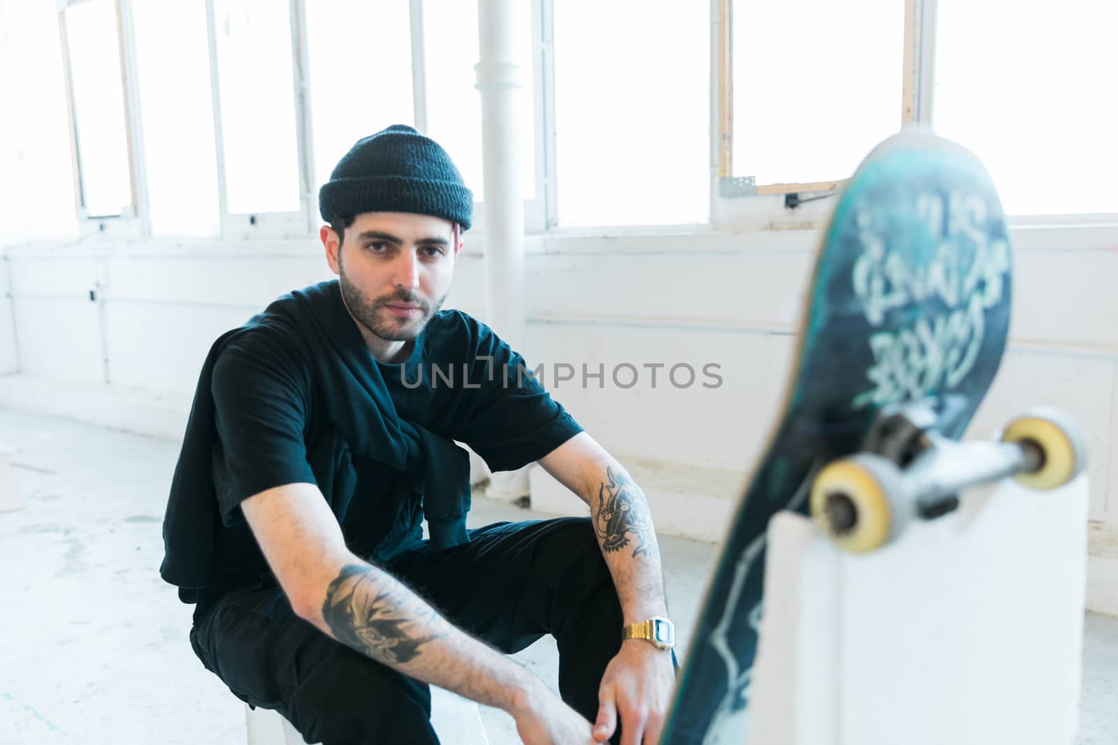 Portrait of relaxed young fashionable skater man in black outfit by camerarules