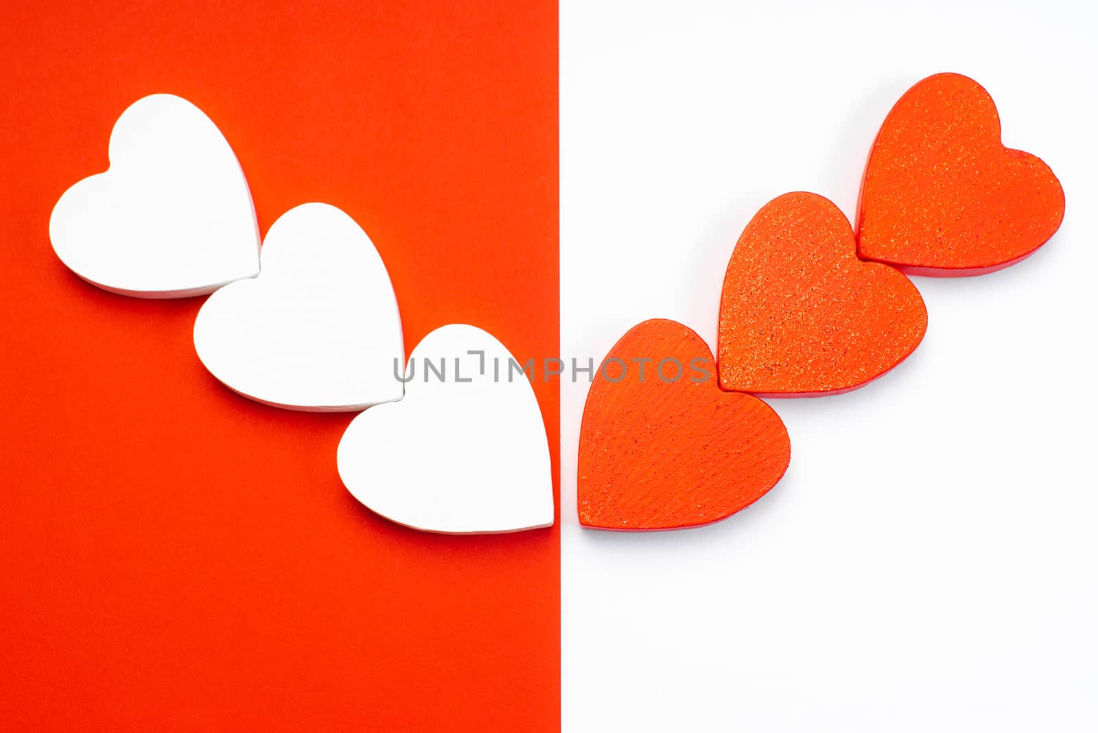White and red wooden hearts on a red and white background. Blank for the designer. Valentines day concept. Greeting card. Valentine's Day. Copy space.