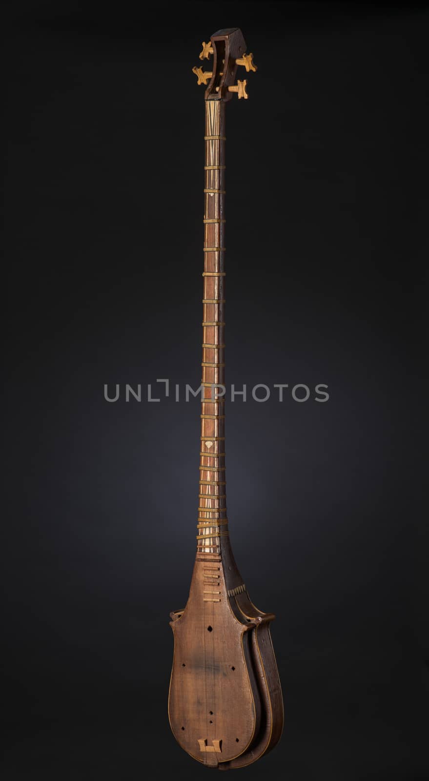 ancient Asian stringed musical instrument on black background with backlight