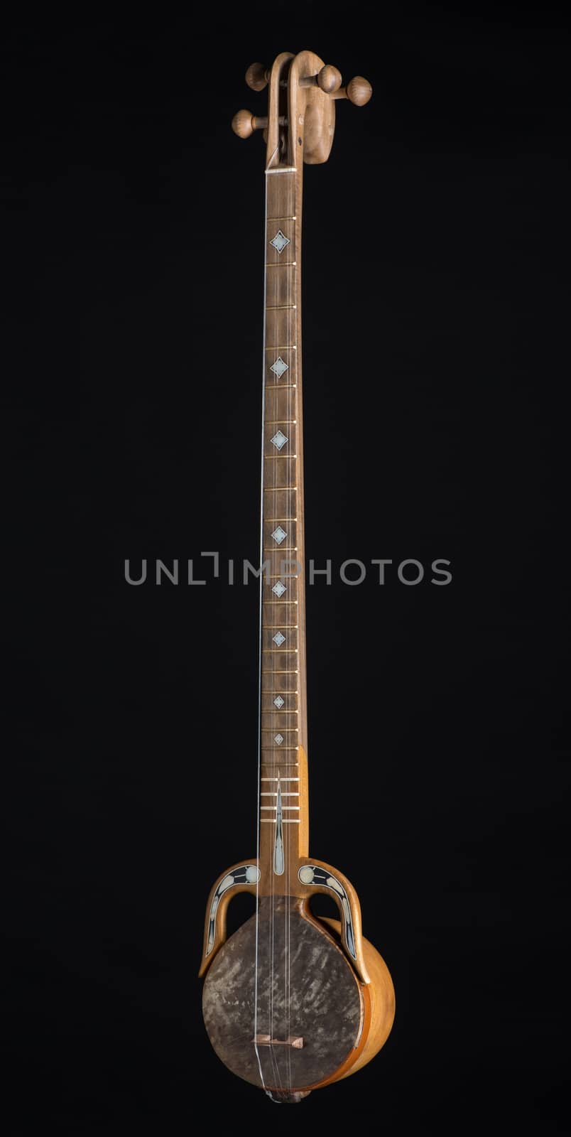 ancient Asian stringed musical instrument on black background with backlight