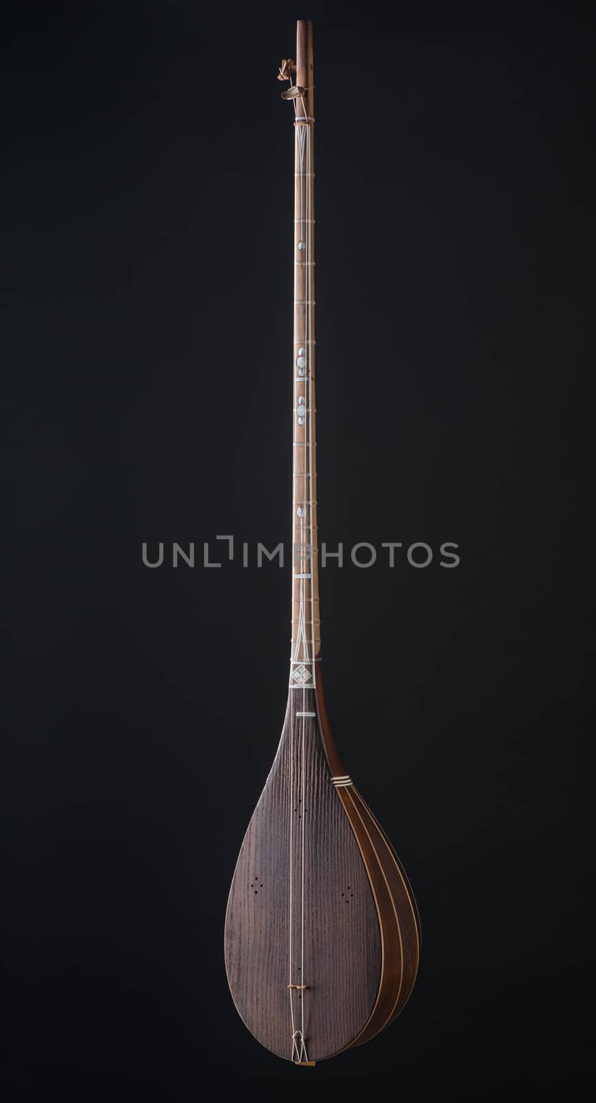 ancient Asian stringed musical instrument on black background with backlight